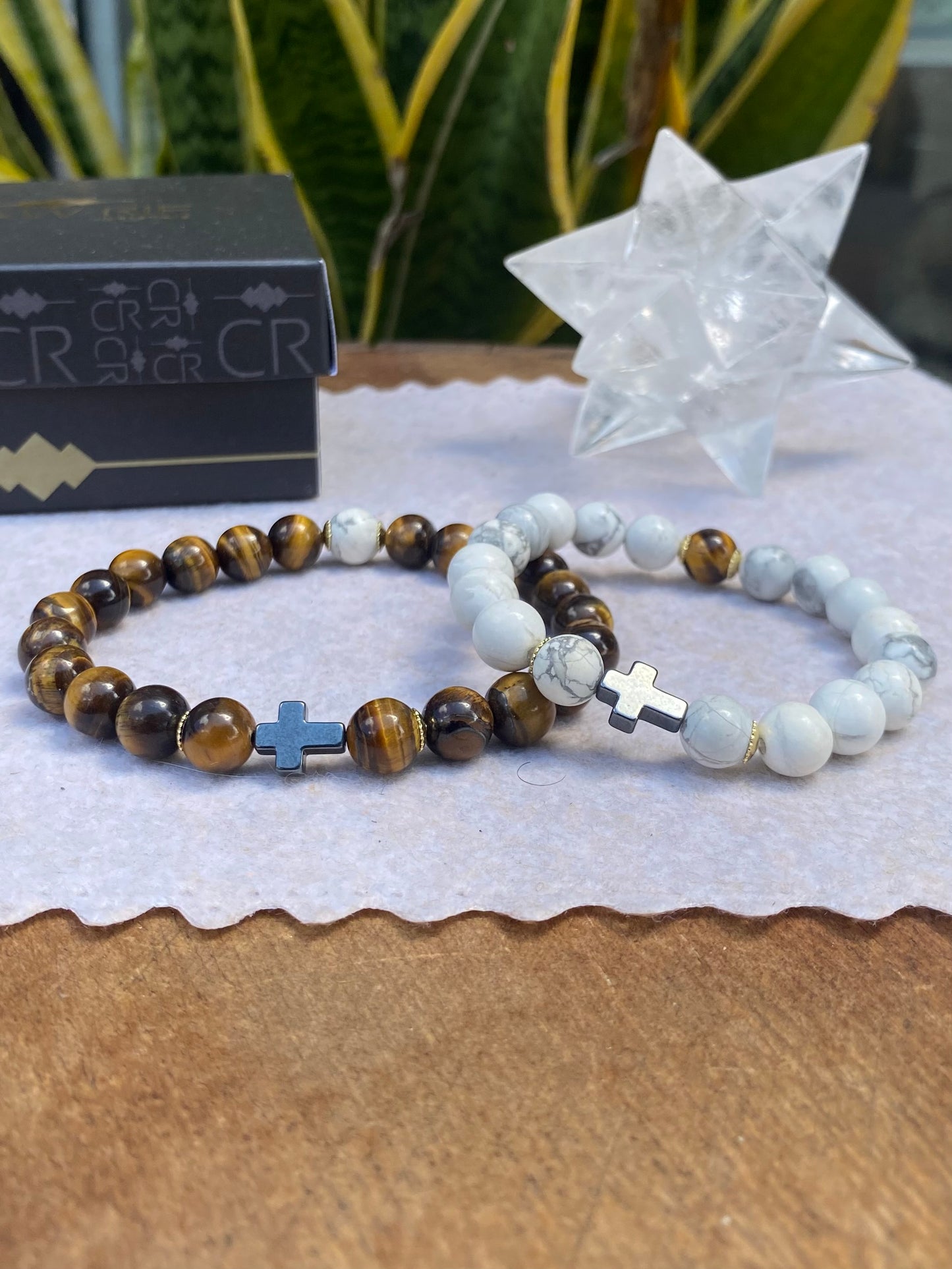 CR Casal | Olho de Tigre e Howlita com Cruz de Hematita – Proteção, Paz e Prosperidade (Banho Ouro 18K)